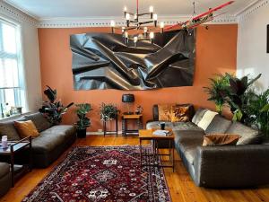 a living room with a couch and a painting on the wall at Spacious historical art oasis in the city center in Bergen