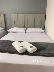 a bed with two white towels on it at Hotel Casa Florida 70 Medellin in Medellín