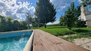 a wooden deck next to a swimming pool at Pool place in Petrovče