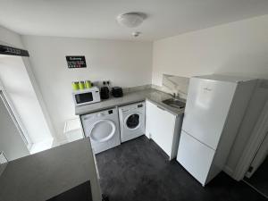 a small kitchen with a washing machine and a washer at The Brooklyn loft apartment in Blackpool