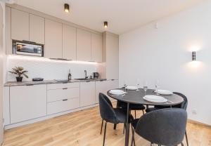 a kitchen and dining room with a table and chairs at Morska Oaza Jantar in Jantar