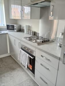 een keuken met een fornuis en een fornuis bovenste oven bij Mesnes Place in Wigan