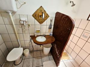 a bathroom with a sink and a toilet and a mirror at Pousada e Hostel Pé no Mato in Vale do Capao +67 photos