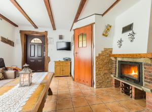 a living room with a fireplace and a table at chatkiagatki in Polańczyk