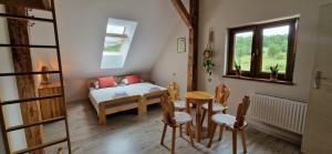 a room with a bed and a table and chairs at Derkaczowa Kotlina in Gniewoszów
