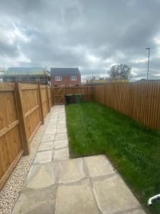 a backyard with a fence and green grass at Mesnes Place in Wigan +27 photos