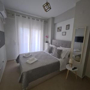 a bedroom with a bed with two towels on it at COZY GOLD #DTerra Apartments# FREE PRIVATE PARKING!! in Thessaloniki