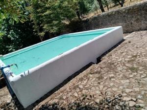 a swimming pool sitting on the ground next to a wall at Casa do Martinho in Castelo de Vide