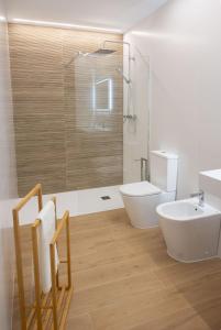 a bathroom with a tub and a sink and a toilet at Rest Pedrouzo in O Pedrouzo