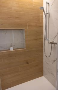 a shower in a bathroom with wooden walls at Rest Pedrouzo in O Pedrouzo