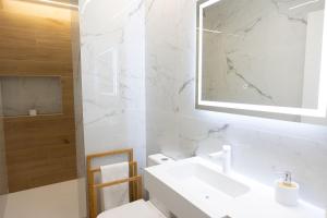 a white bathroom with a sink and a mirror at Rest Pedrouzo in O Pedrouzo