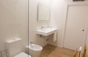 a white bathroom with a sink and a toilet at Rest Pedrouzo in O Pedrouzo
