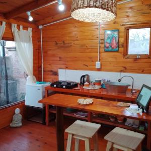 a kitchen with a table in a wooden cabin at FINCA los nogales in General Belgrano