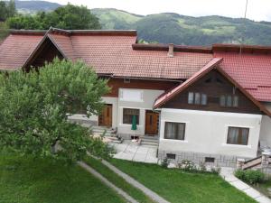 una casa con techo rojo y patio en Pensiunea Laura, en Bran