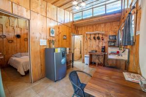a kitchen with wooden walls and a table and a refrigerator at Villa Tabacon in Monteverde Costa Rica