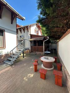 a patio with benches and a table in front of a house at Harmony & Wine Eger in Eger