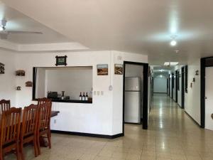 a hallway with a table and chairs and a refrigerator at Hotel de conveniencia Travesía urbana in San José