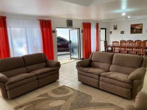 two couches in a living room with red curtains at Hotel de conveniencia Travesía urbana in San José