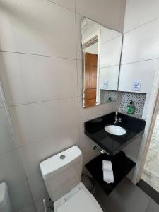 a bathroom with a white toilet and a sink at Apartamento Paraíso da Ilha Porchat ! *Novíssimo!* in São Vicente +42 photos