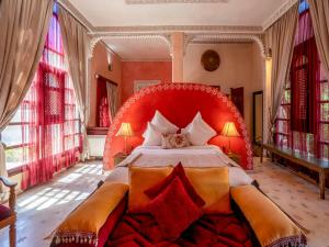 ein Schlafzimmer mit einem großen Bett mit rotem Kopfteil in der Unterkunft Riad Clé De Sol & SPA in El Jemʼa Ghemat