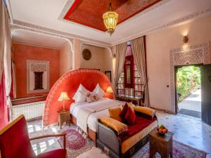 ein Schlafzimmer mit einem großen Bett und einer Couch in der Unterkunft Riad Clé De Sol & SPA in El Jemʼa Ghemat