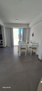 a living room with a white table and chairs at Amanecerpuertomadryn 1 in Puerto Madryn