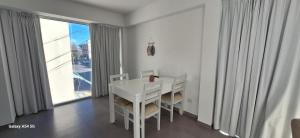 a white table and chairs in a room with a window at Amanecerpuertomadryn 1 in Puerto Madryn