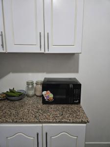 a black microwave on a counter in a kitchen at Room Vision City 2020 in Kigali