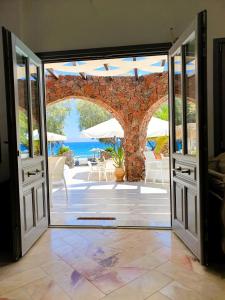 an open door to a patio with a view of the ocean at Arion Bay Hotel Santorini in Kamari