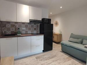a kitchen and a couch in a living room at T1 - Bord de Mer in Six-Fours-les-Plages