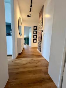 a hallway with wood floors and a mirror at stilvoll-modern-neu - 15 min to Düsseldorf Messe in Meerbusch