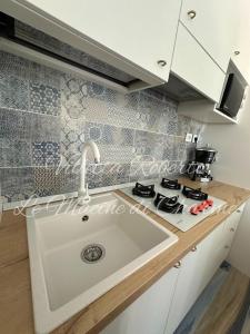 a kitchen with a sink and a stove at Villetta Roberto Le Macine di Charme - Pugnochiuso Resort in Vieste
