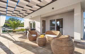 a patio with rattan chairs and a table at Villa Magdalena in Polača