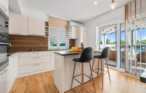 a kitchen with white cabinets and a counter with stools at Villa Magdalena in Polača