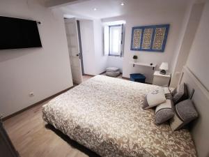 a bedroom with a bed and a flat screen tv at Castle House and Beach in Sines +47 photos