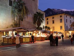a group of people standing around a market with christmas lights at Appartamento Capri in Arco