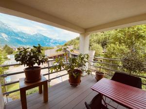 a porch with potted plants and a table on a balcony at Maisonette im Penthouse-Stil ca 145m2 mit viel Privatsphäre - direkt am Walensee mit Badestrand in Unterterzen