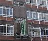 a tall building with windows and a green sign on it at Euro Hotel in Curitiba