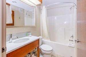 a bathroom with a sink and a toilet and a mirror at Rivers Edge Motel in Cherokee +40 photos