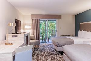 a hotel room with two beds and a television at Rivers Edge Motel in Cherokee