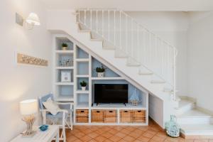 a living room with a tv under the stairs at Maison Cir&igrave; in Forte dei Marmi