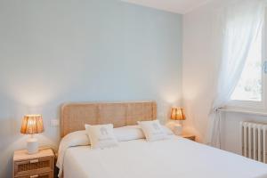 a bedroom with a white bed with two lamps at Maison Cir&igrave; in Forte dei Marmi
