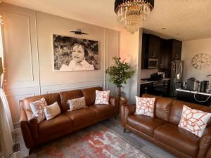 a living room with two brown leather couches at Z FamilyHome Suites & Apartments in Calgary