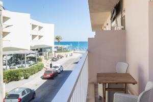 a balcony with a table and a view of the beach at Theo Apartment Rethymno in Rethymno