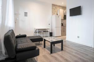 un soggiorno con un divano e un tavolo di Hogar en Calle Lavapiés a Madrid Altre 10 foto