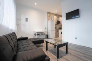 un soggiorno con un divano e un tavolo di Hogar en Calle Lavapiés a Madrid