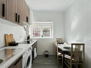 eine weiße Küche mit Spüle und Tisch in der Unterkunft Oasis Suite in Avila
