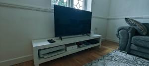 a living room with a flat screen tv on a white entertainment center at Family house in Greenwich in Eltham