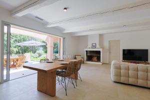 a dining room with a table and a couch at Villa avec piscine in Plan-de-la-Tour