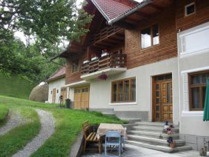 Una casa con una mesa y sillas delante de ella. en Pensiunea Laura, en Bran